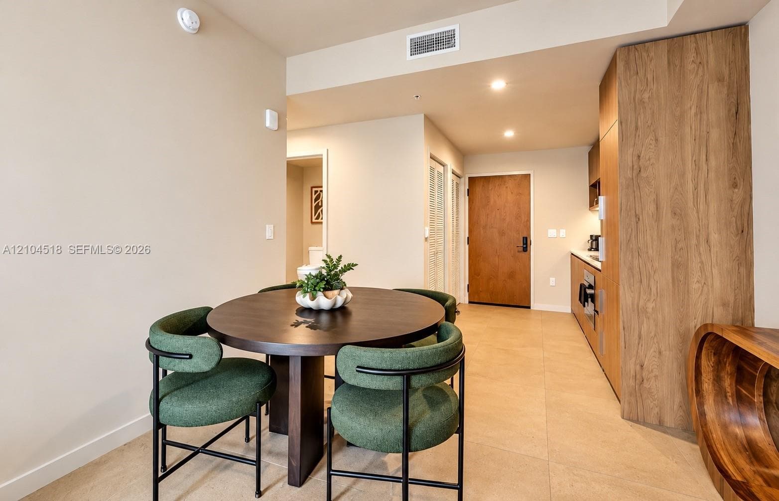 Compact kitchen featuring wood-finish cabinetry, integrated appliances, and recessed lighting