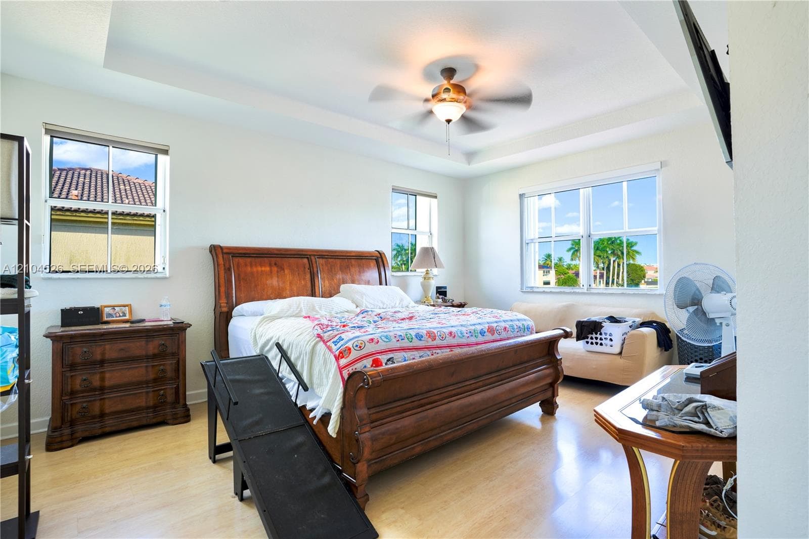 Tray ceiling, ceiling fan with integrated light fixture, and wood-finish flooring