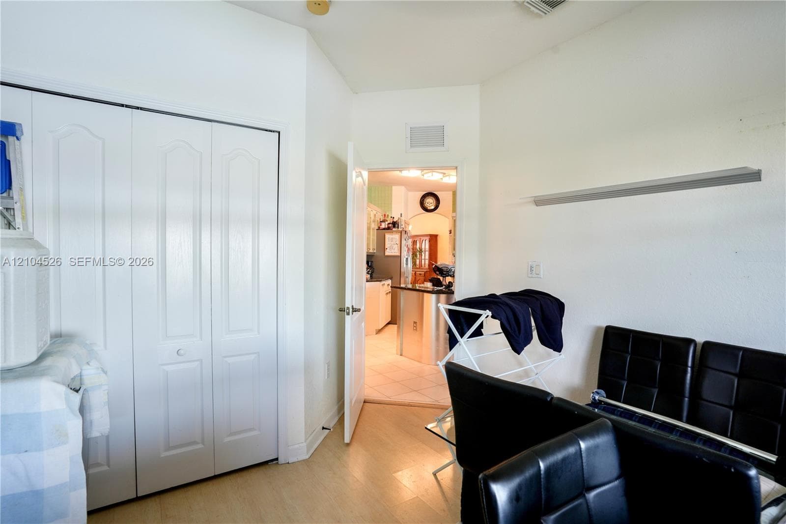 Interior space featuring bi-fold closet doors, neutral wall finish, and wood-finish flooring