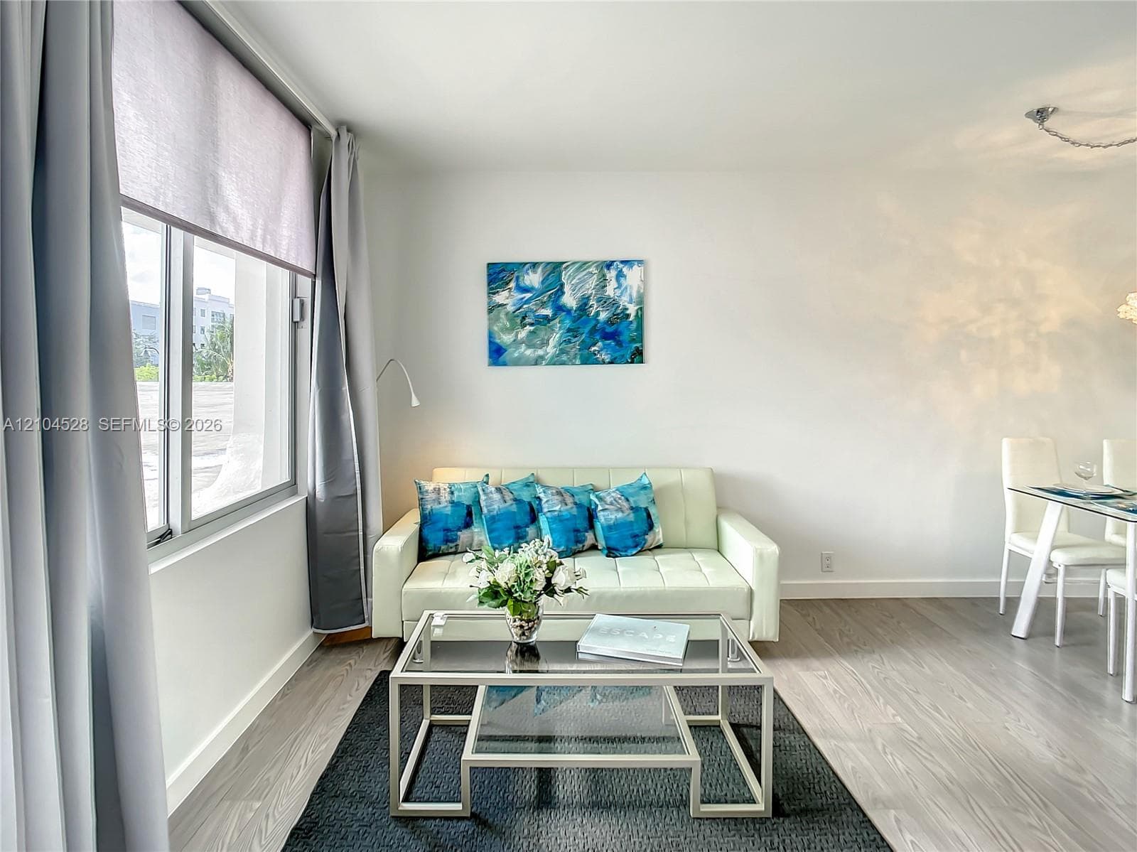 Light-filled room featuring neutral wall tones, wood-finish flooring, and expansive windows