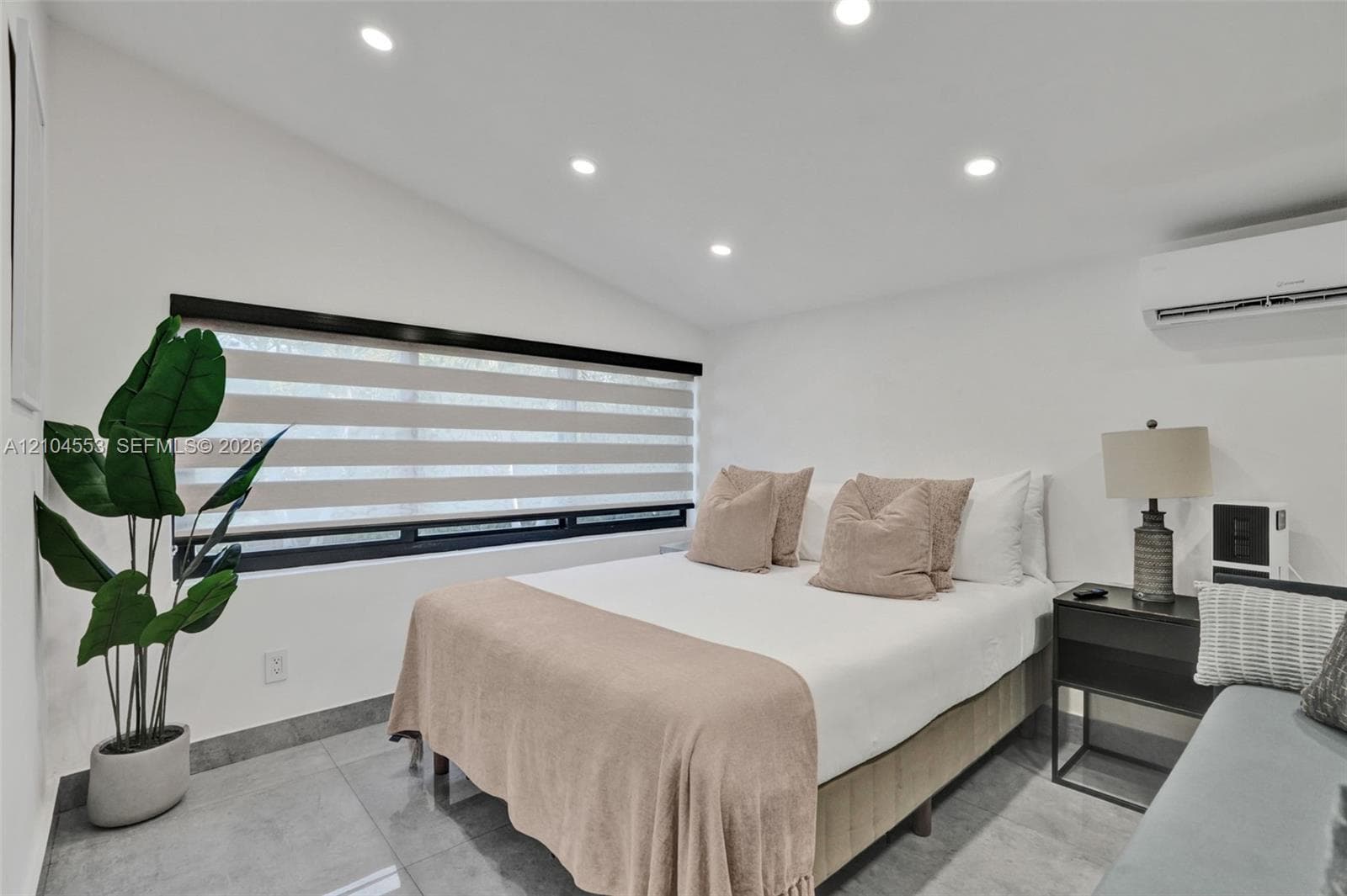 Recessed ceiling lighting, large-format tile flooring, horizontal window shades, and wall-mounted climate control unit
