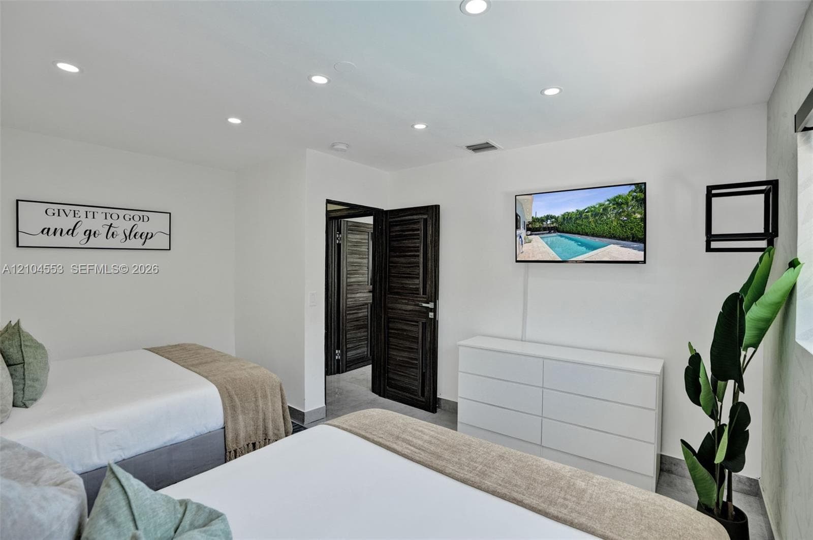 Neutral interior featuring recessed lighting, smooth white wall finishes, and dark-stained wood-finish doors