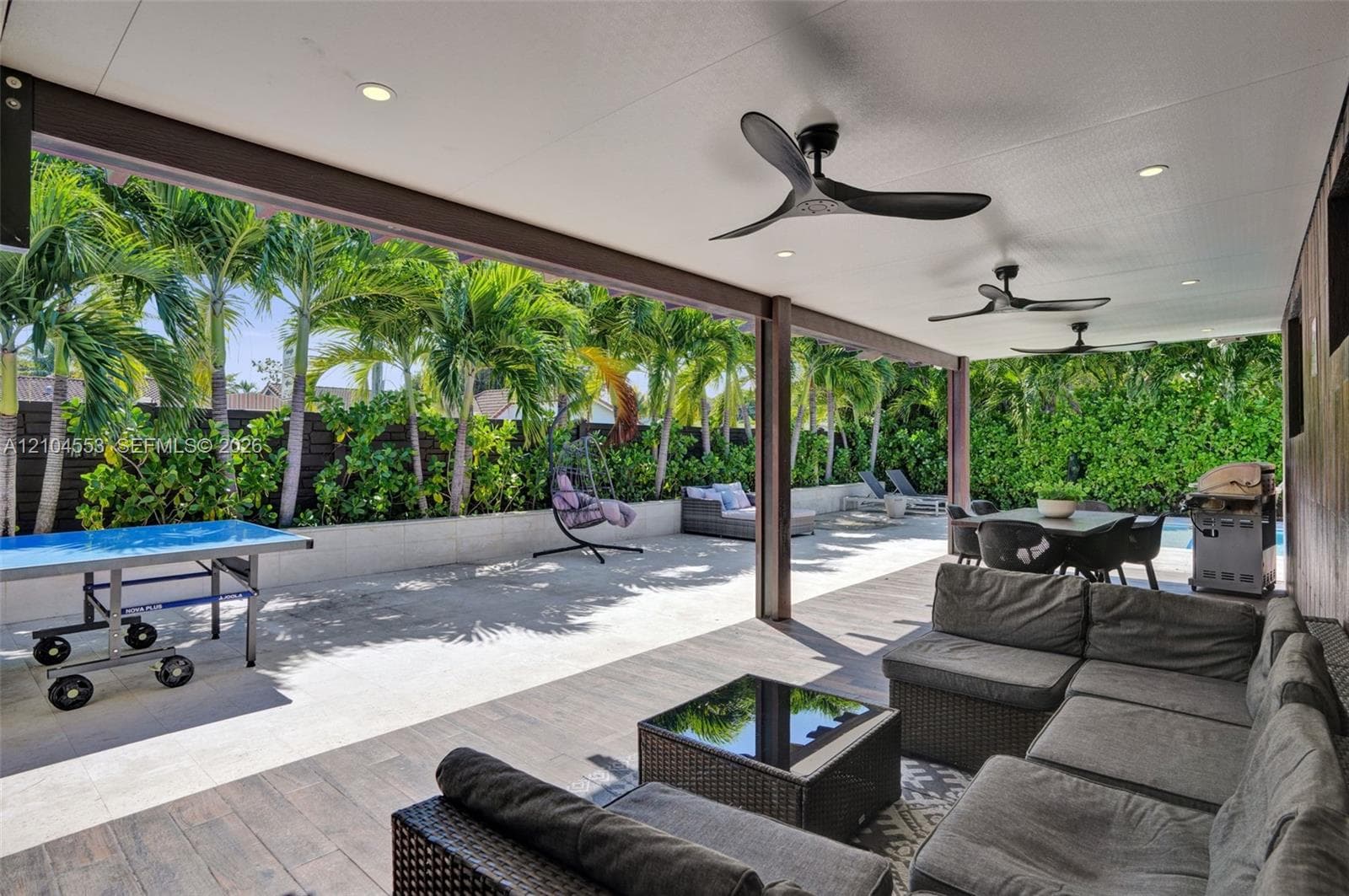 Covered patio featuring wood-finish flooring, recessed lighting, and multi-blade ceiling fans