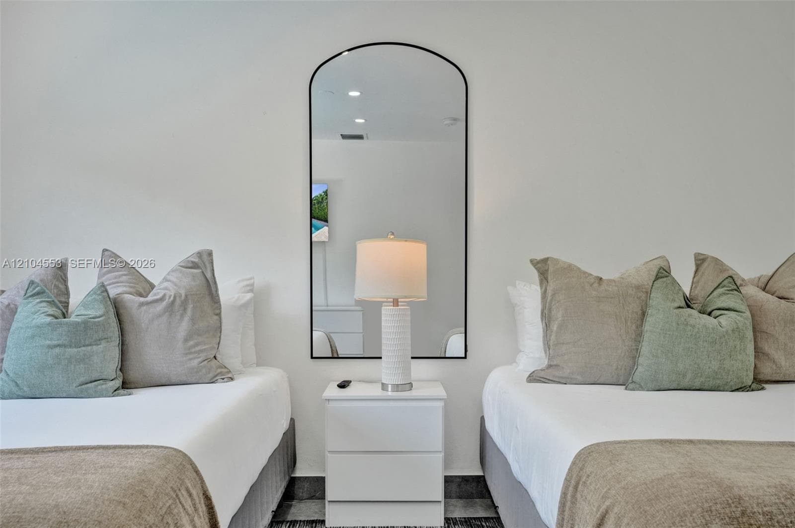 Arched wall-mounted mirror featuring a slim black frame