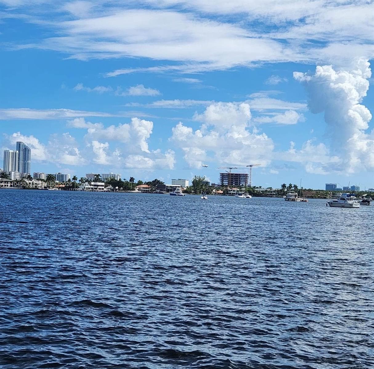 Direct waterfront exposure featuring expansive waterway, maritime vessels, and coastal skyline backdrop