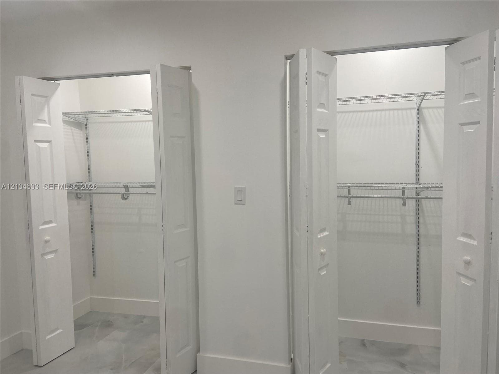 Dual closets featuring bi-fold panel doors and adjustable wire shelving systems
