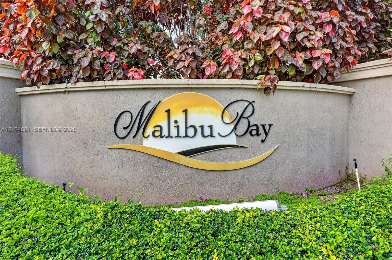 Stucco monument sign featuring dimensional lettering and manicured landscaping