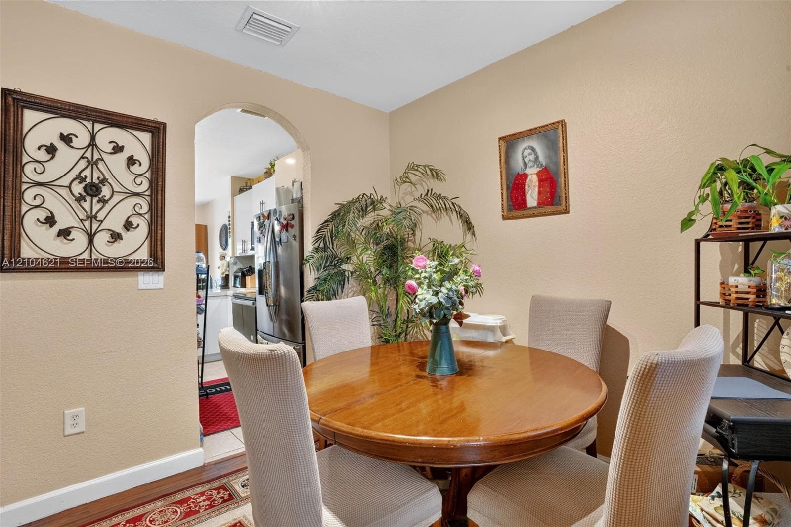 Dining space featuring an arched entryway and wood-finish flooring