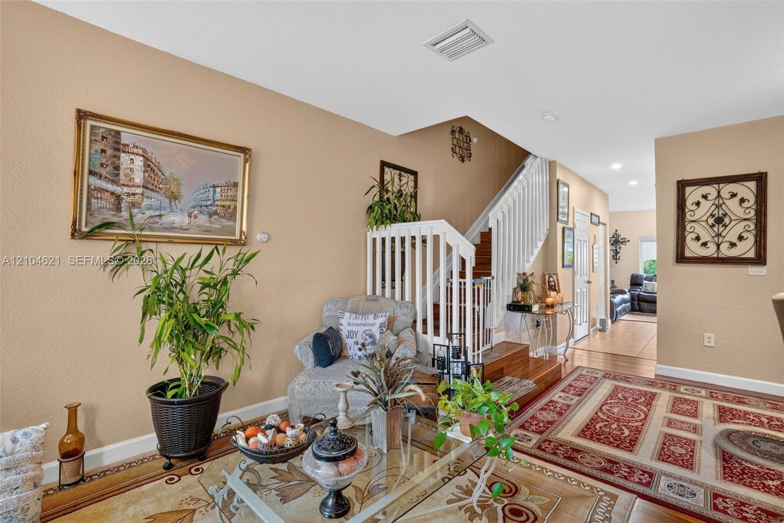Interior space featuring wood-finish staircase with white balusters and railings, recessed ceiling lighting, and solid surface flooring