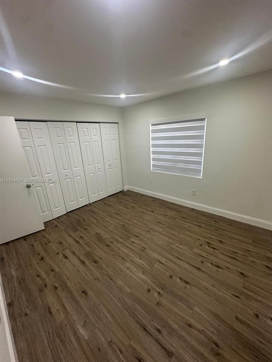 Wood-finish flooring, recessed lighting, horizontal window blinds, and bi-fold closet doors