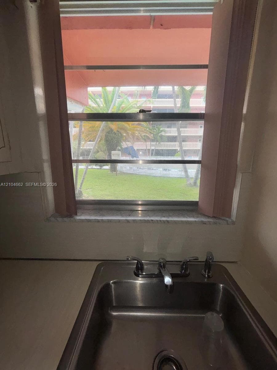 Stainless steel sink with dual handles and a central faucet