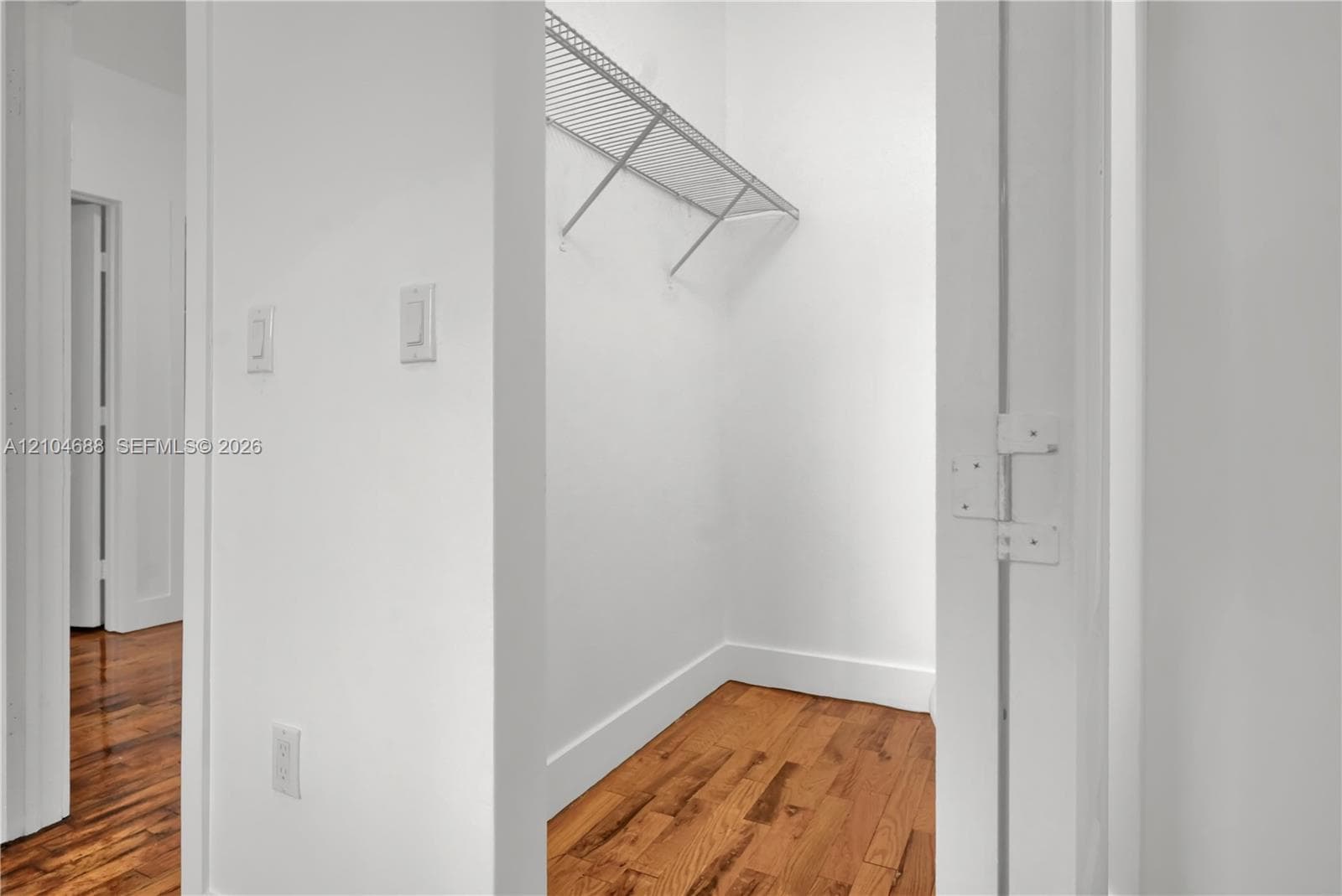 Closet space featuring wood-finish flooring and integrated wire shelving