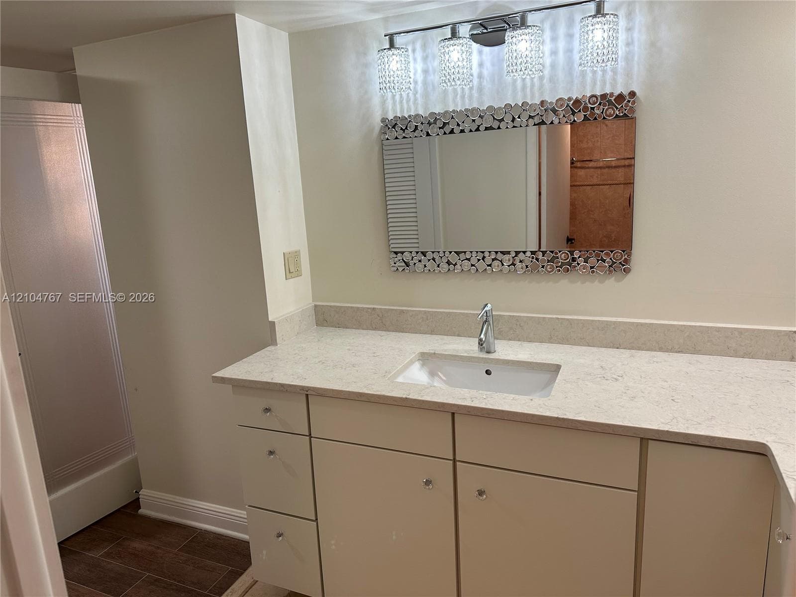 Wood-finish flooring, decorative ceiling medallion, multi-tiered crystal chandelier, and crown molding