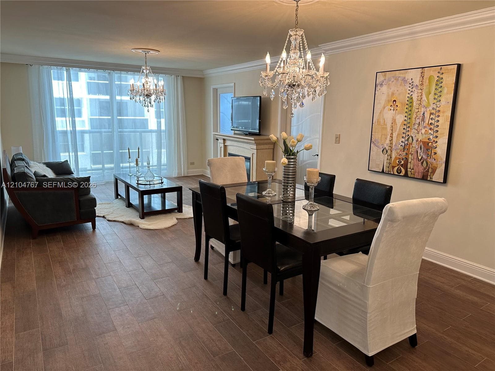 Ornamental crystal chandelier, crown molding, and wood-finish flooring