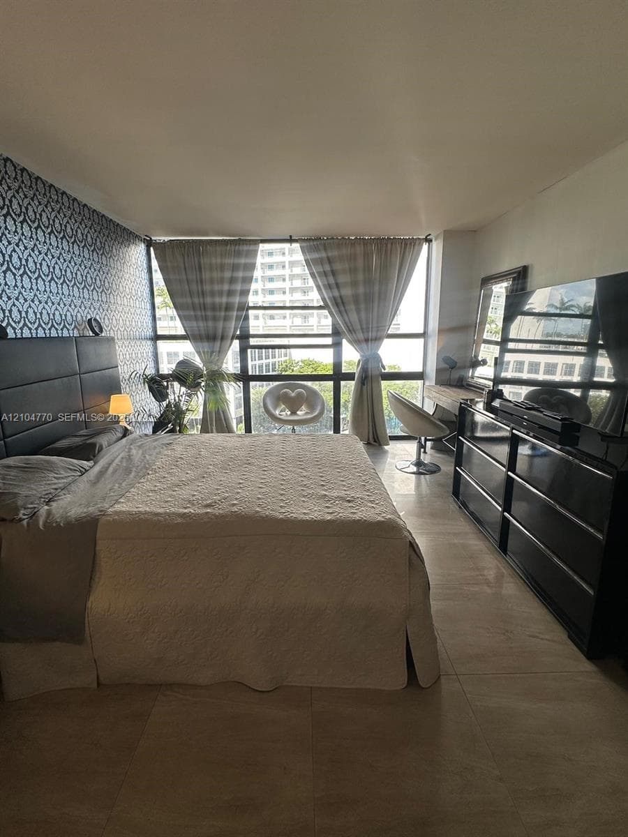Large window, patterned accent wall, tile flooring