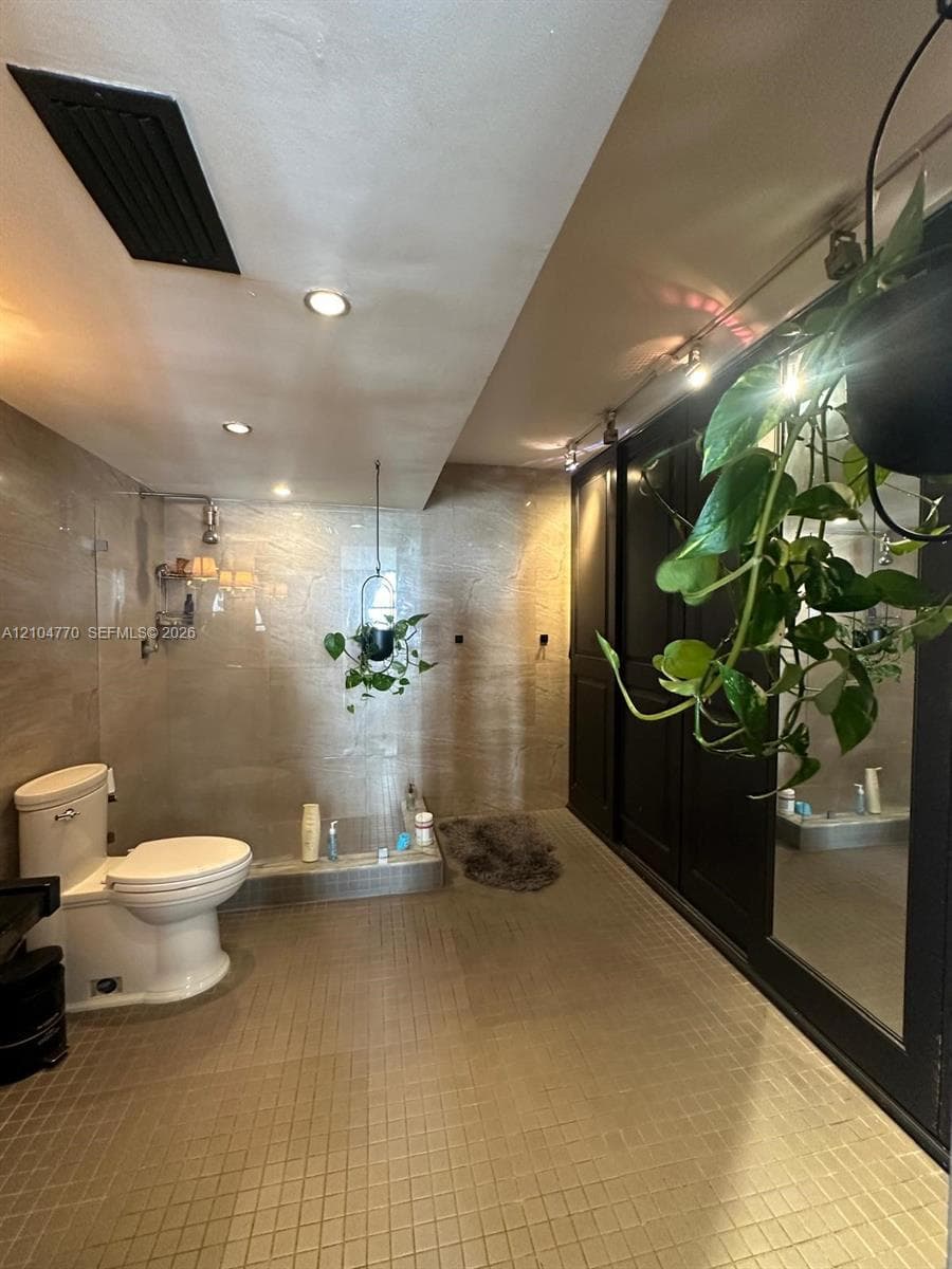 Recessed ceiling lighting, track lighting, and a white toilet