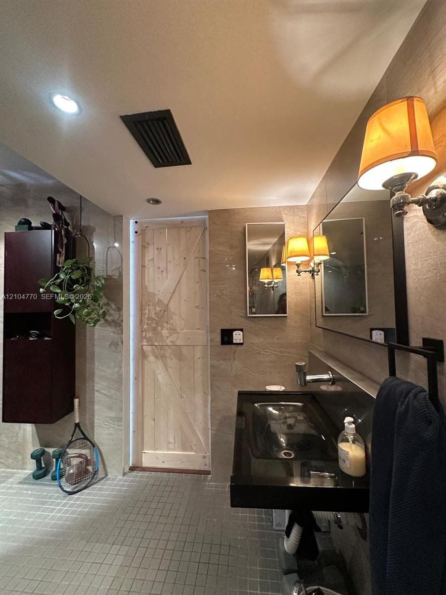 Floating black vanity with an integrated basin, wall-mounted faucet, and full-width mirror