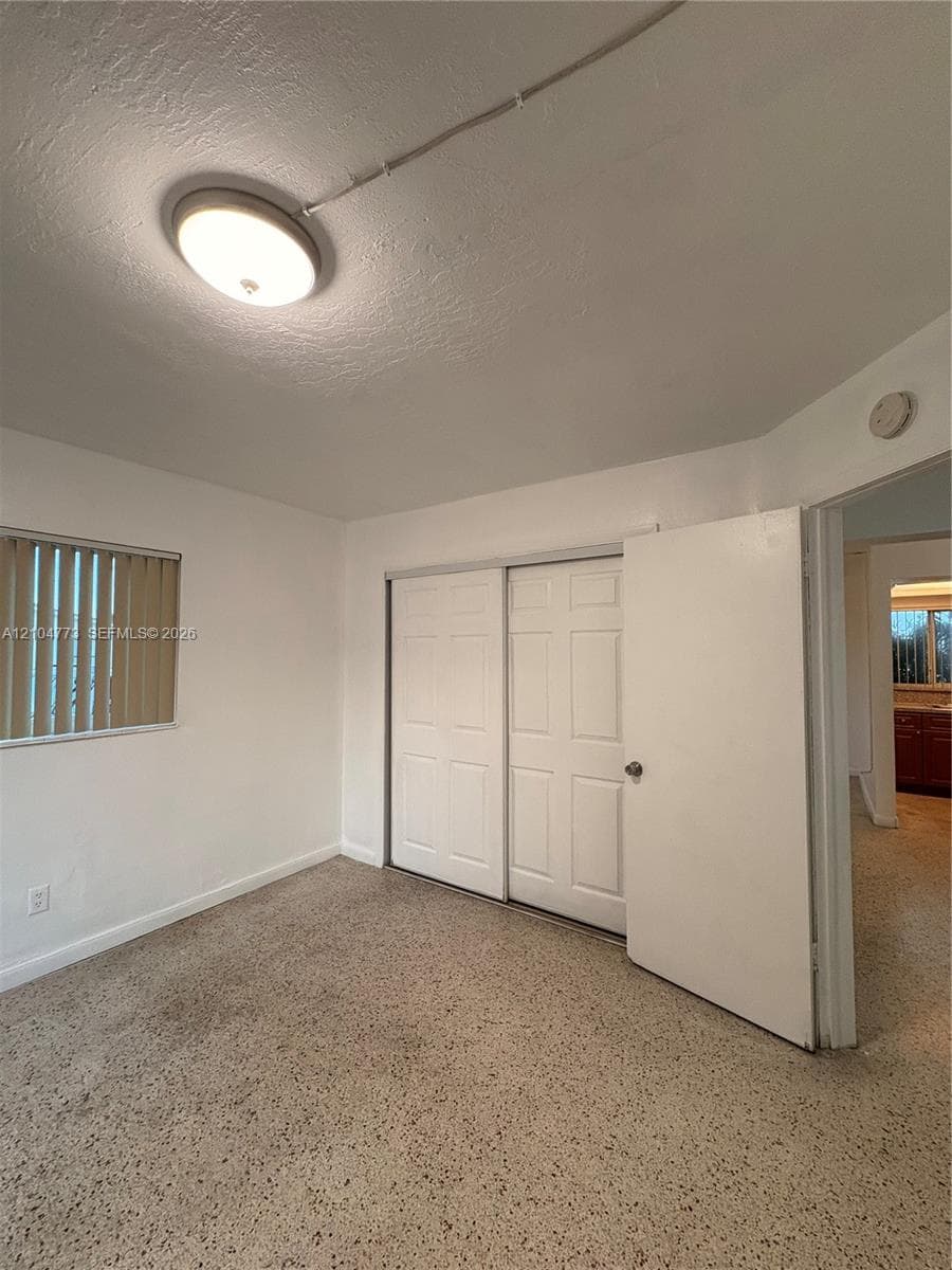Recessed lighting fixture, sliding closet doors, window with blinds, wall-to-wall flooring