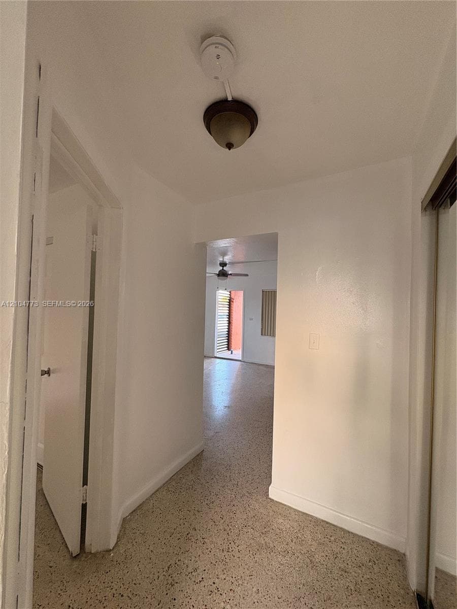 Hallway with terrazzo flooring and a flush-mount light fixture