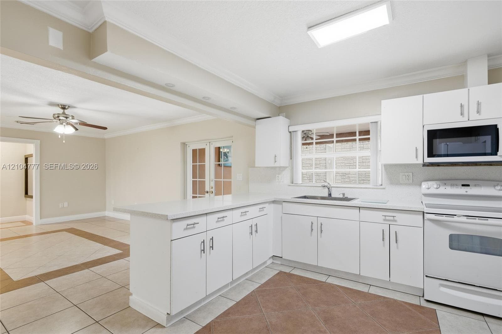Kitchen featuring white cabinetry, white appliances, solid surface countertops, and tile flooring