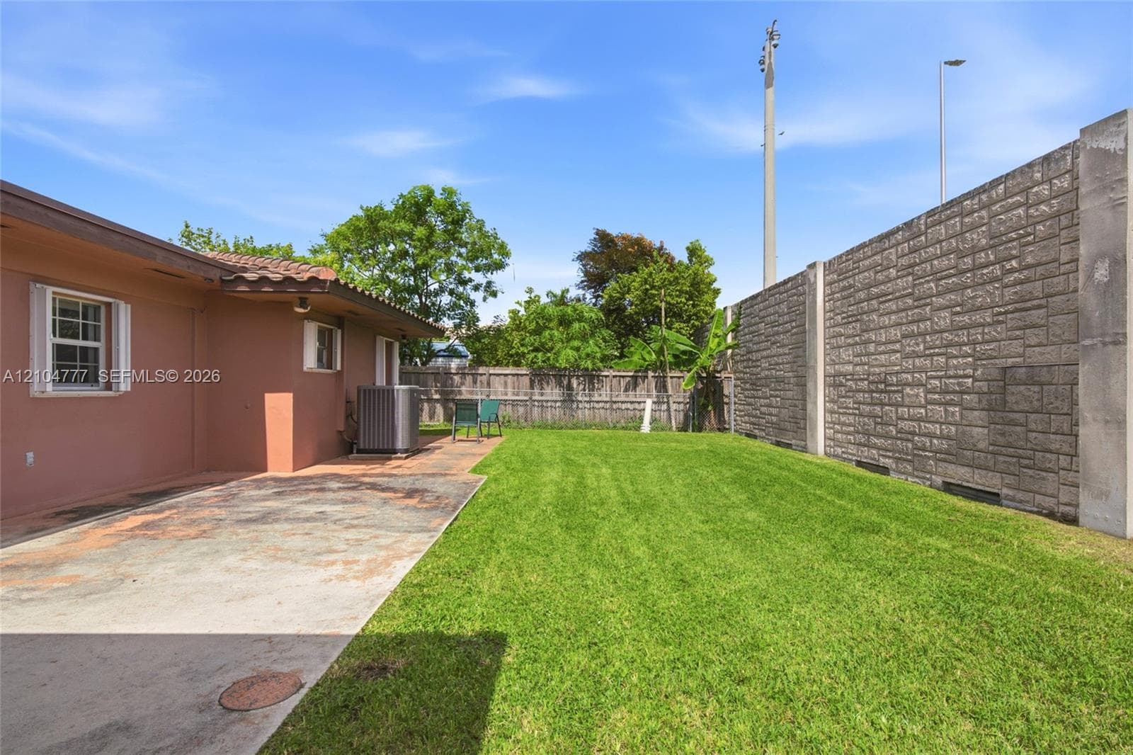 Expansive grassy yard with a concrete patio