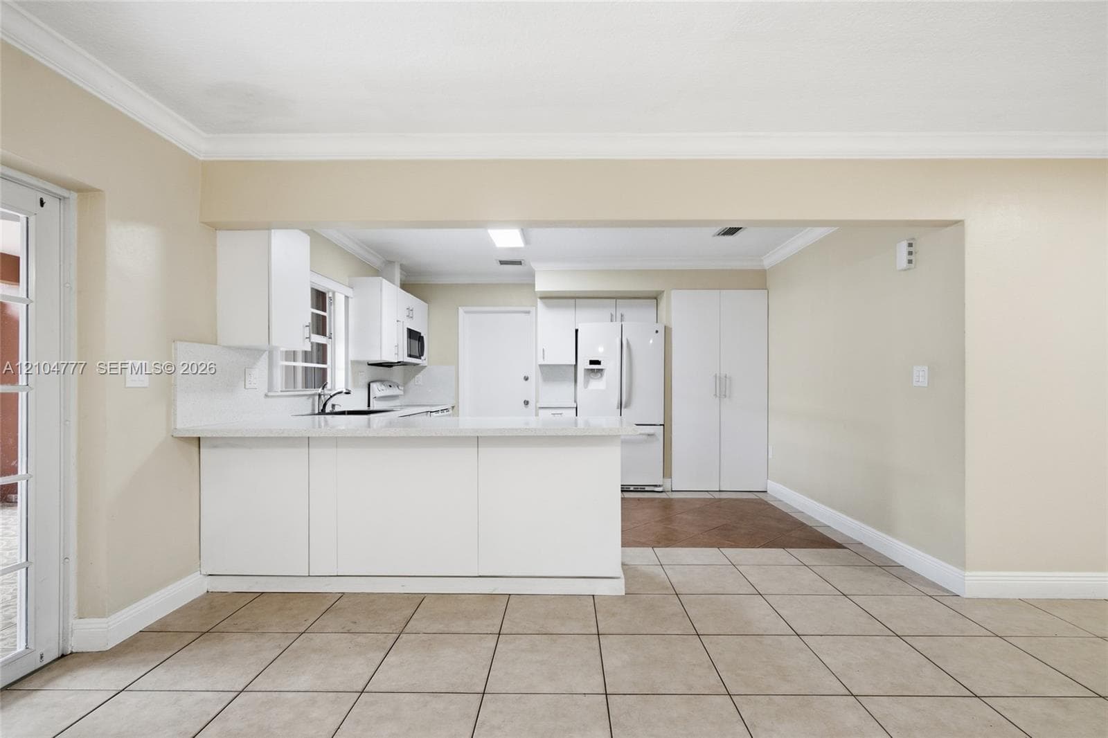 Kitchen with white cabinetry, stainless steel appliances, and a pass-through window