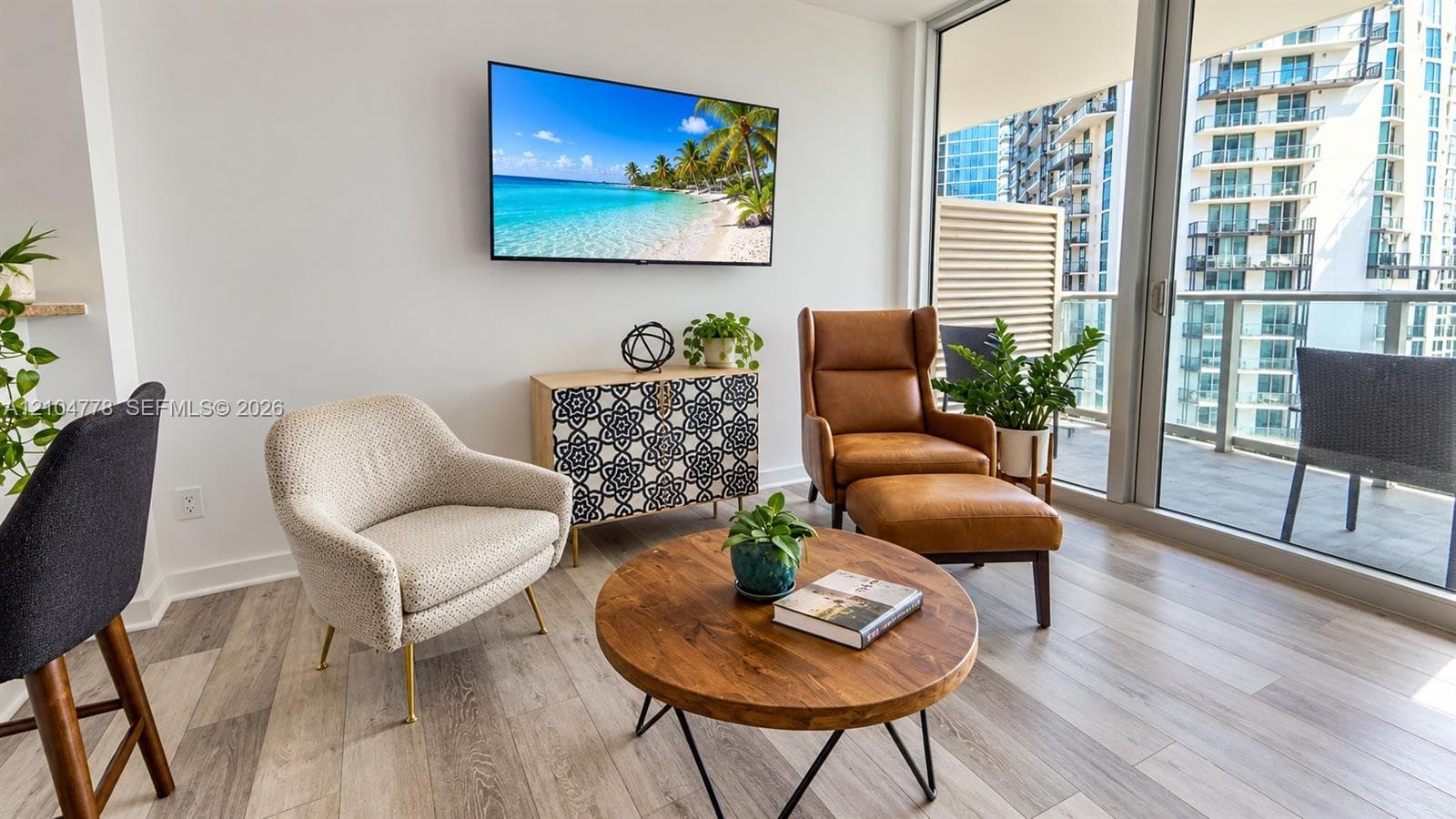 Wood-finish flooring, full-height glass doors, and a spacious balcony with glass railings
