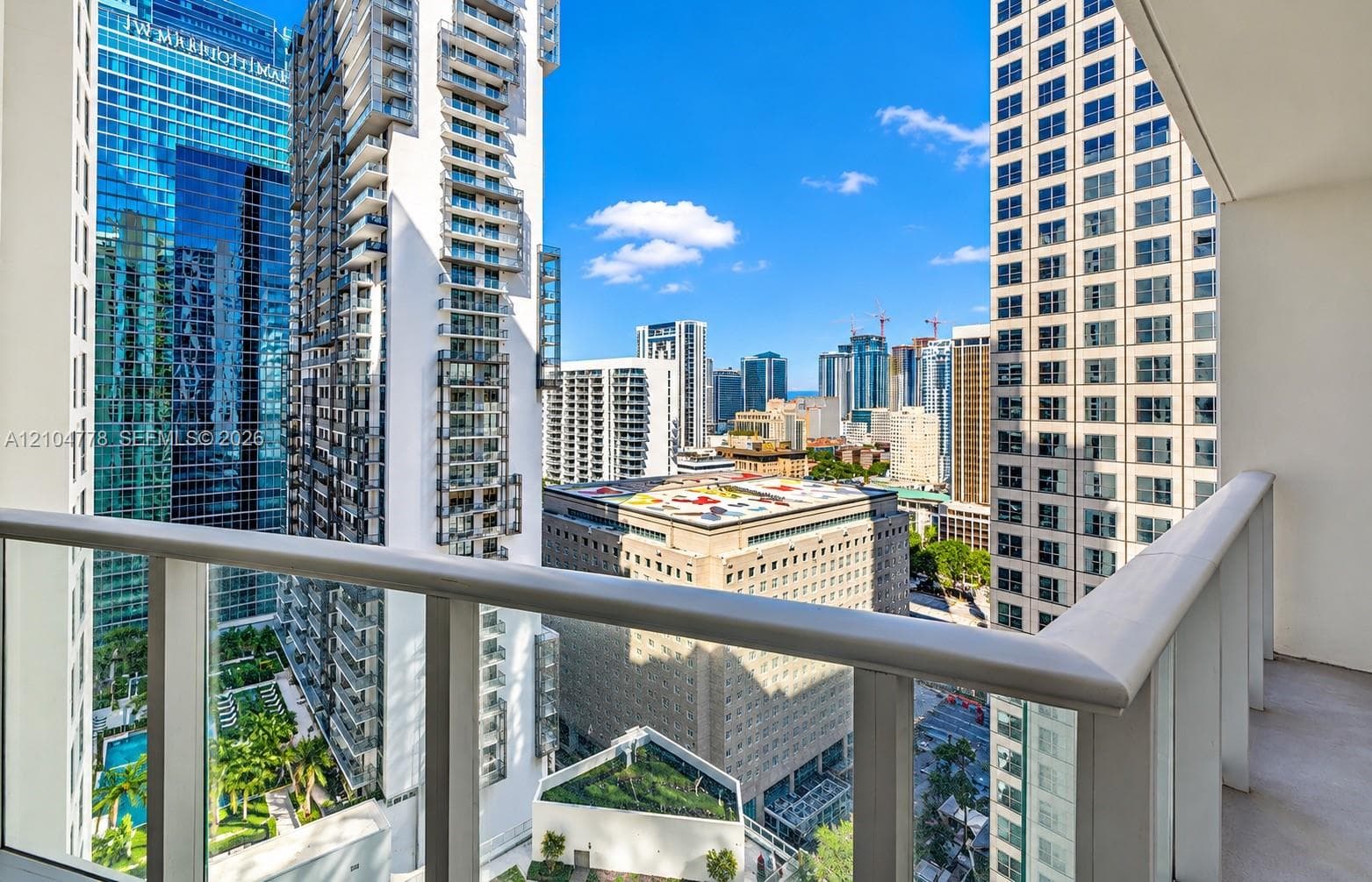 Balcony with glass panel railing and painted concrete flooring