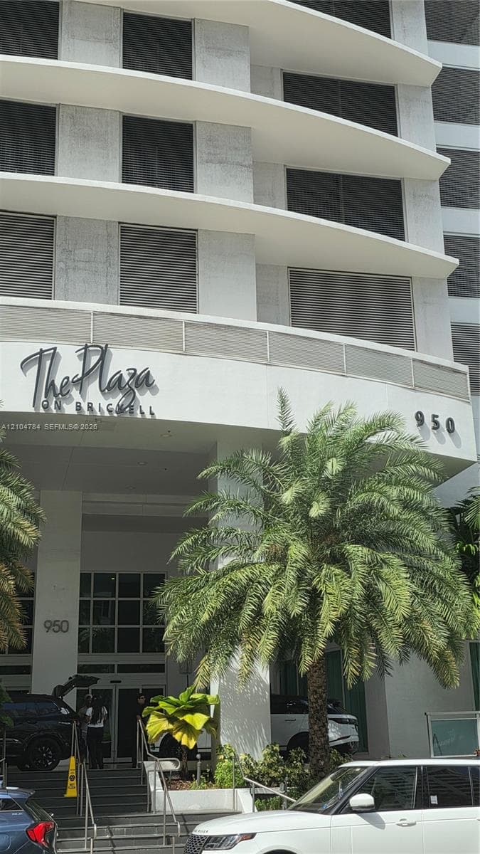High-rise exterior featuring curved structural balconies, floor-to-ceiling windows, and integrated metal privacy screens