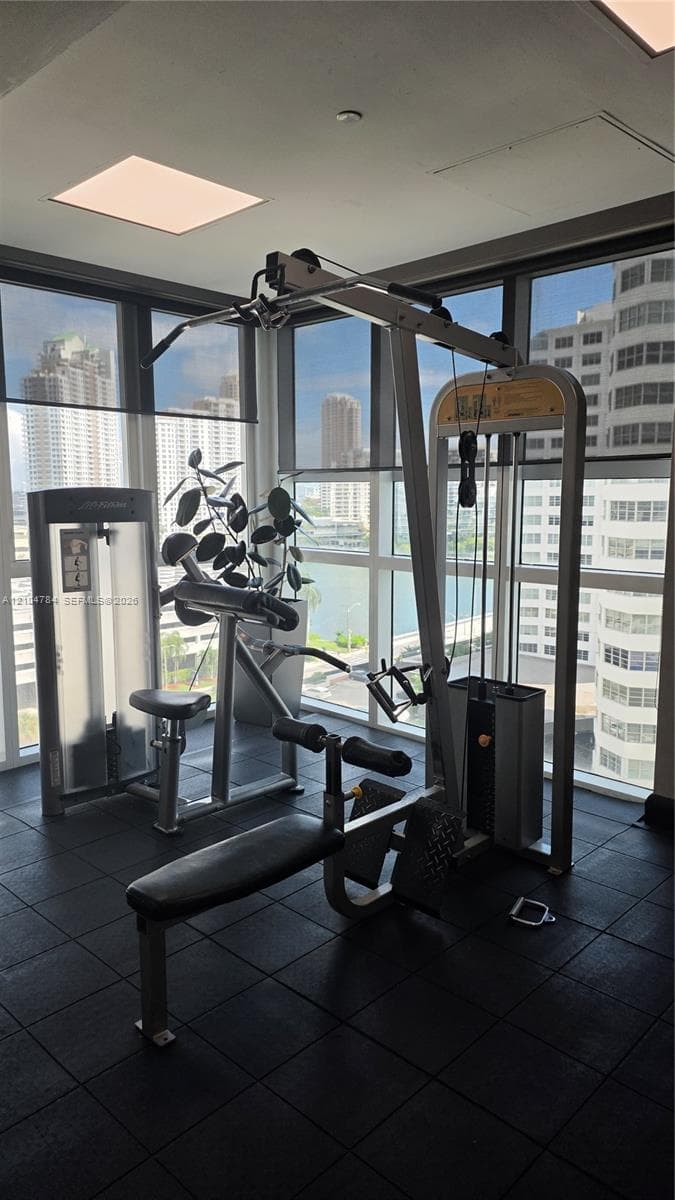 Fitness area featuring floor-to-ceiling windows, dark rubberized flooring, and recessed ceiling lighting