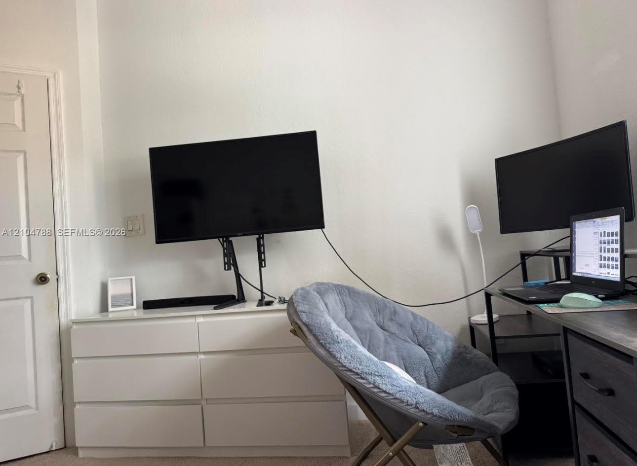 Interior room featuring a six-panel door with a metallic knob and neutral wall finish
