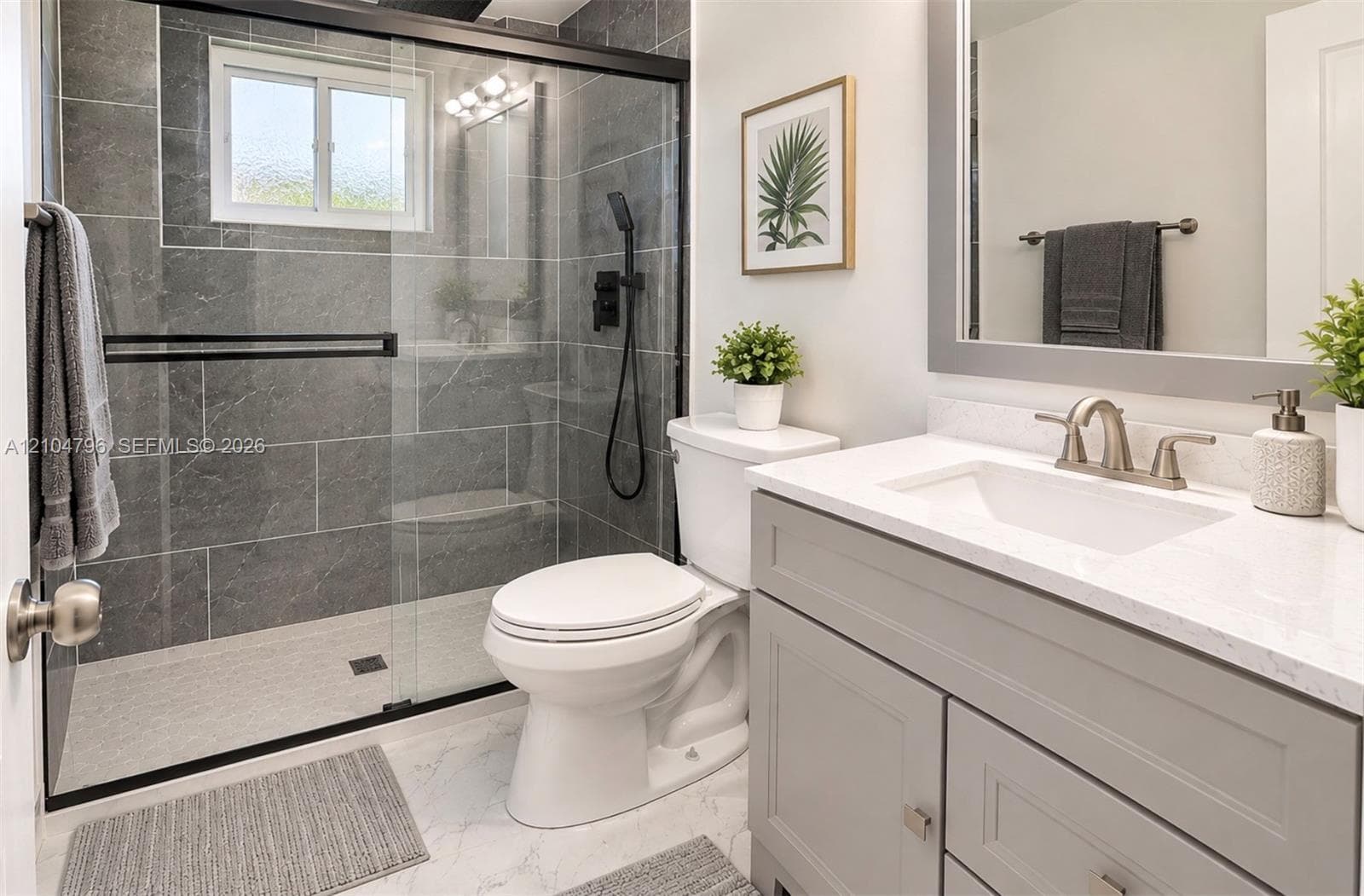 Walk-in shower with floor-to-ceiling tile, sliding glass door, and matte black hardware
