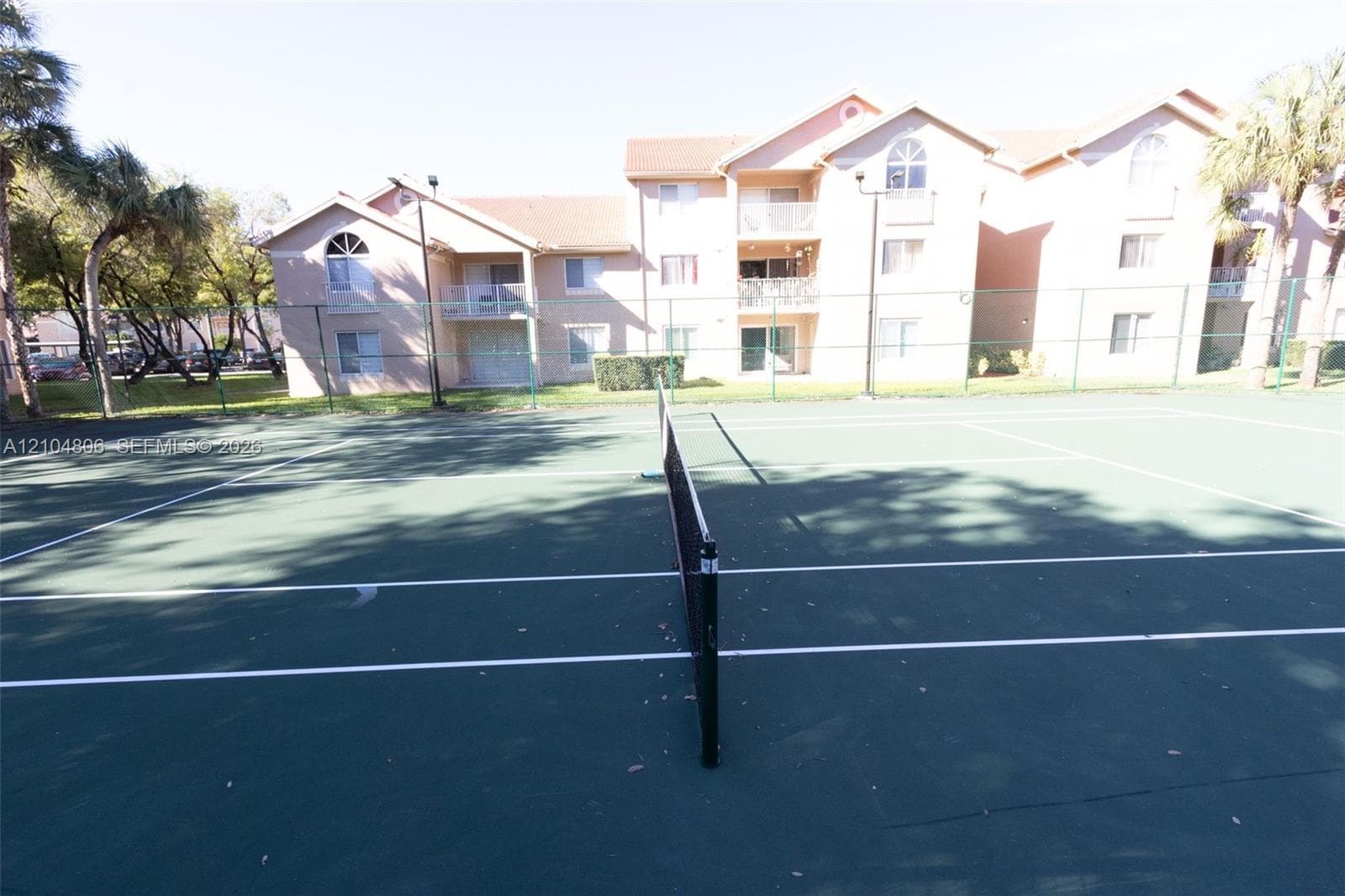 Tennis court featuring a green playing surface and white court lines