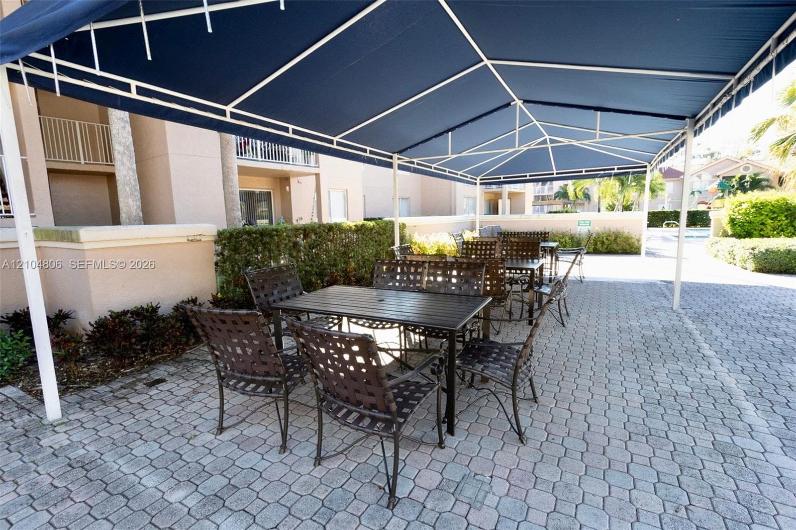 Paved patio area featuring a fixed overhead canopy
