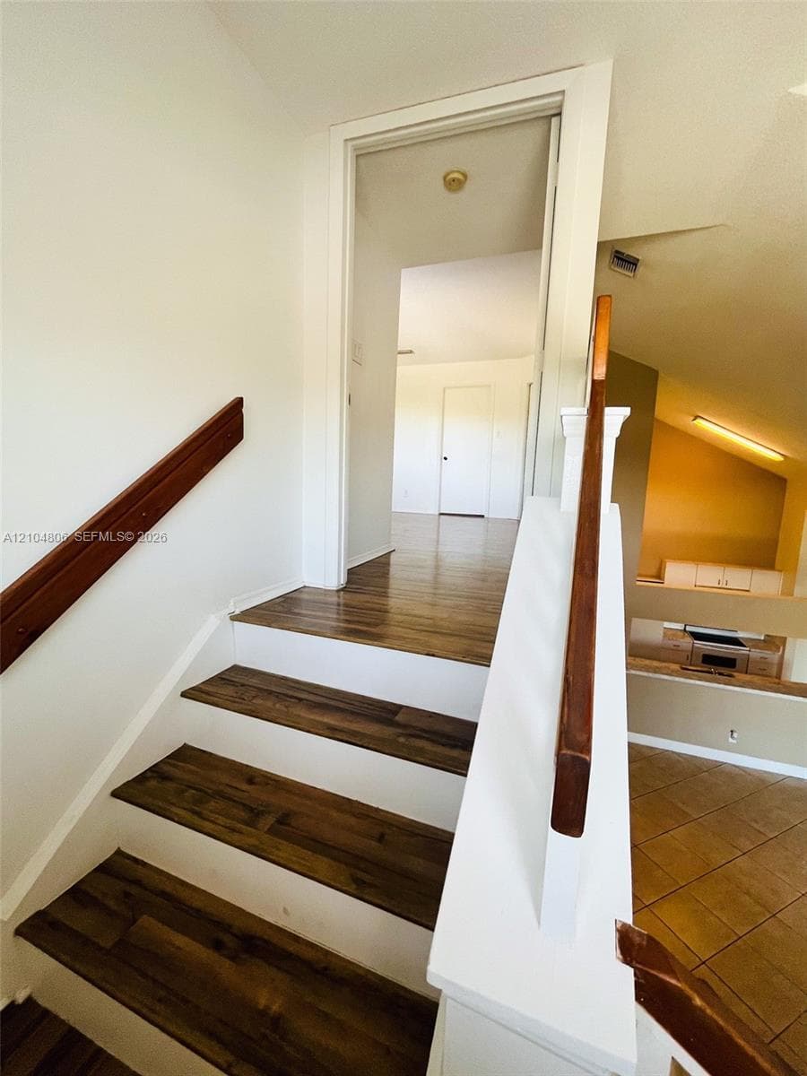Staircase featuring wood-finish treads and white risers
