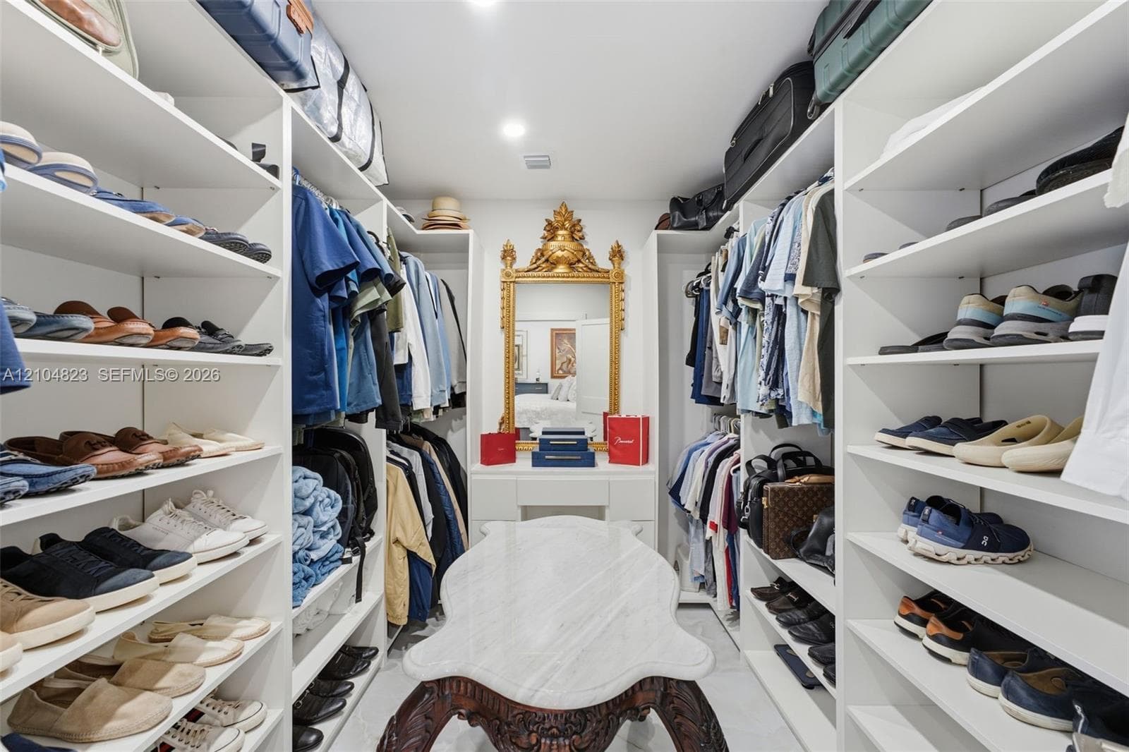 Custom closet system with extensive shelving, integrated hanging rods, and recessed lighting