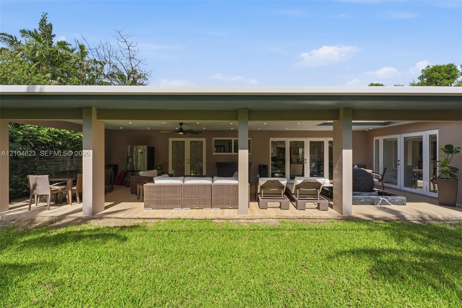 Expansive covered patio featuring a wood-finish deck, recessed lighting, and multiple sets of French doors