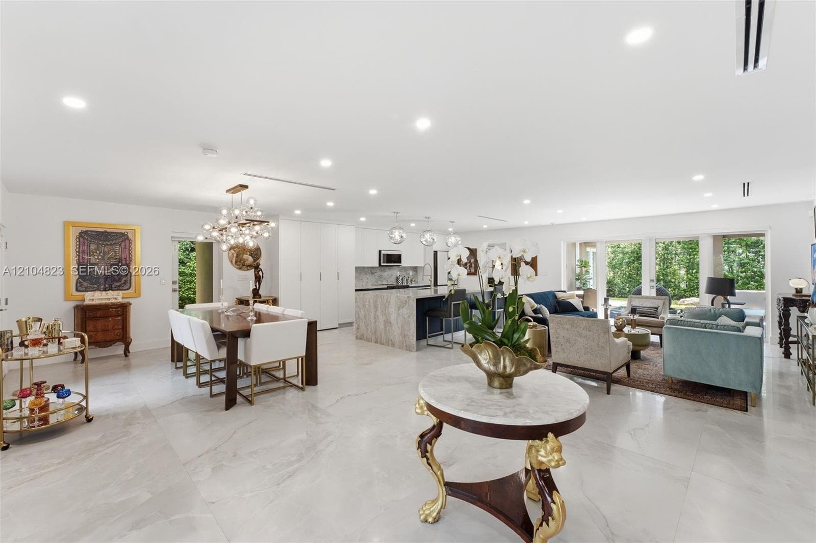 Expansive open-concept space with large format tile flooring, recessed lighting, and a contemporary chandelier