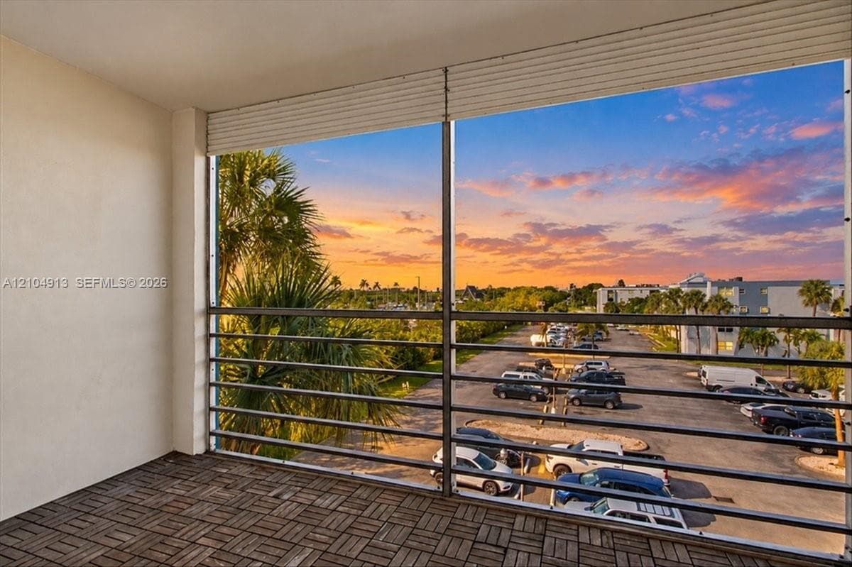 Covered balcony featuring wood-finish deck tiling and horizontal metal railing