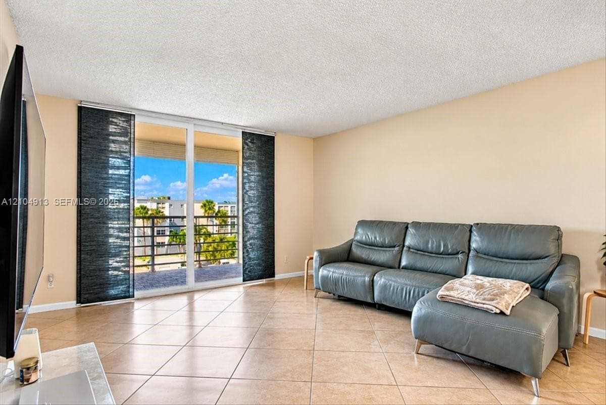 Living area featuring tile flooring, sliding glass doors, and a private balcony