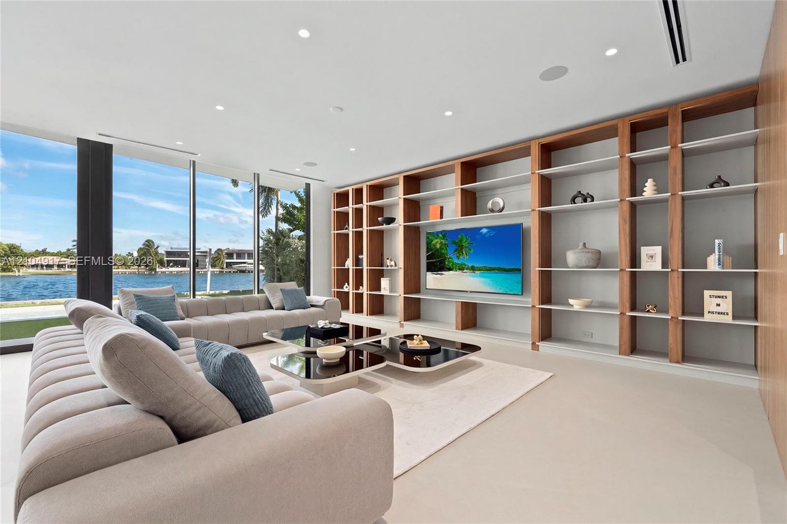 Full-height window walls, custom built-in shelving with integrated media space, recessed lighting, and light-toned flooring