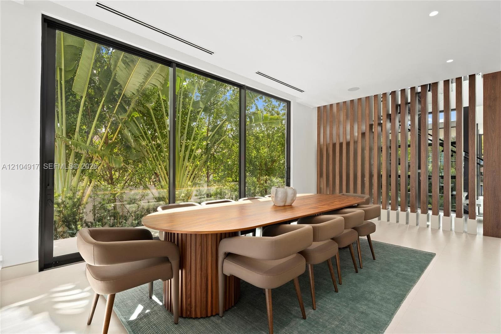 Floor-to-ceiling windows, recessed lighting, wood-finish slatted wall partition, and light-toned flooring