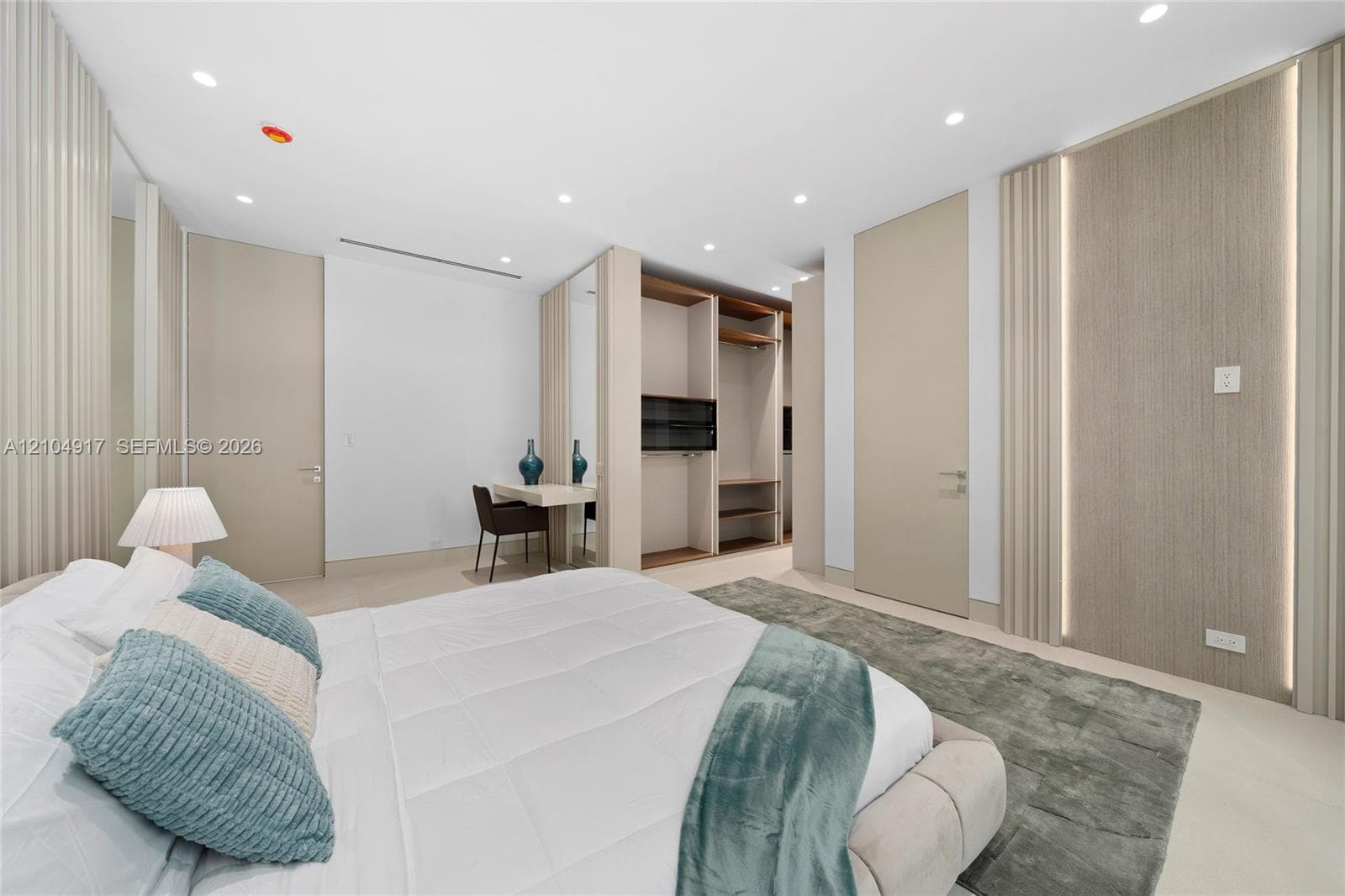 Recessed ceiling lighting, built-in open shelving, integrated wall lighting, light-toned wood-finish flooring, and a built-in desk area