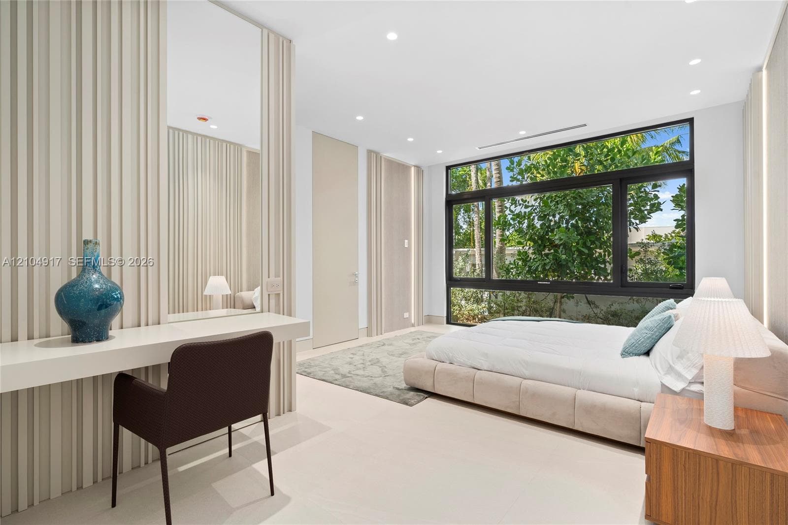 Expansive window system with dark framing, recessed lighting, light-toned flooring, and a built-in vanity with mirror