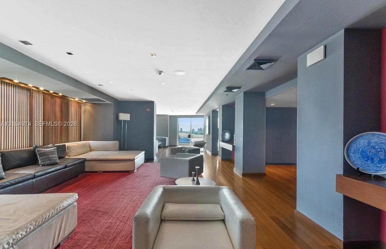 Open-concept space featuring wood-finish flooring, recessed lighting, and a vertical wood-slat accent wall