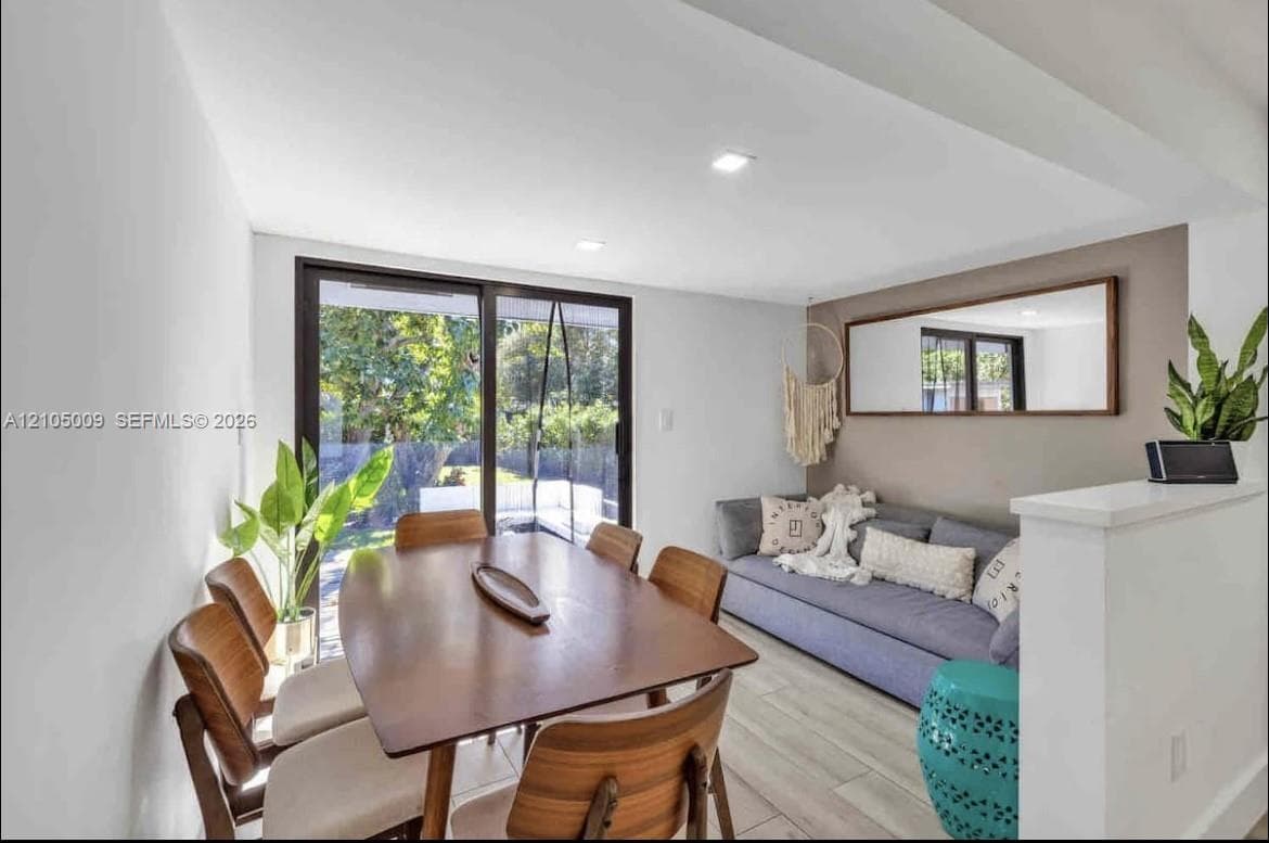 Sliding glass doors, recessed lighting, wood-finish flooring, and a half-wall partition