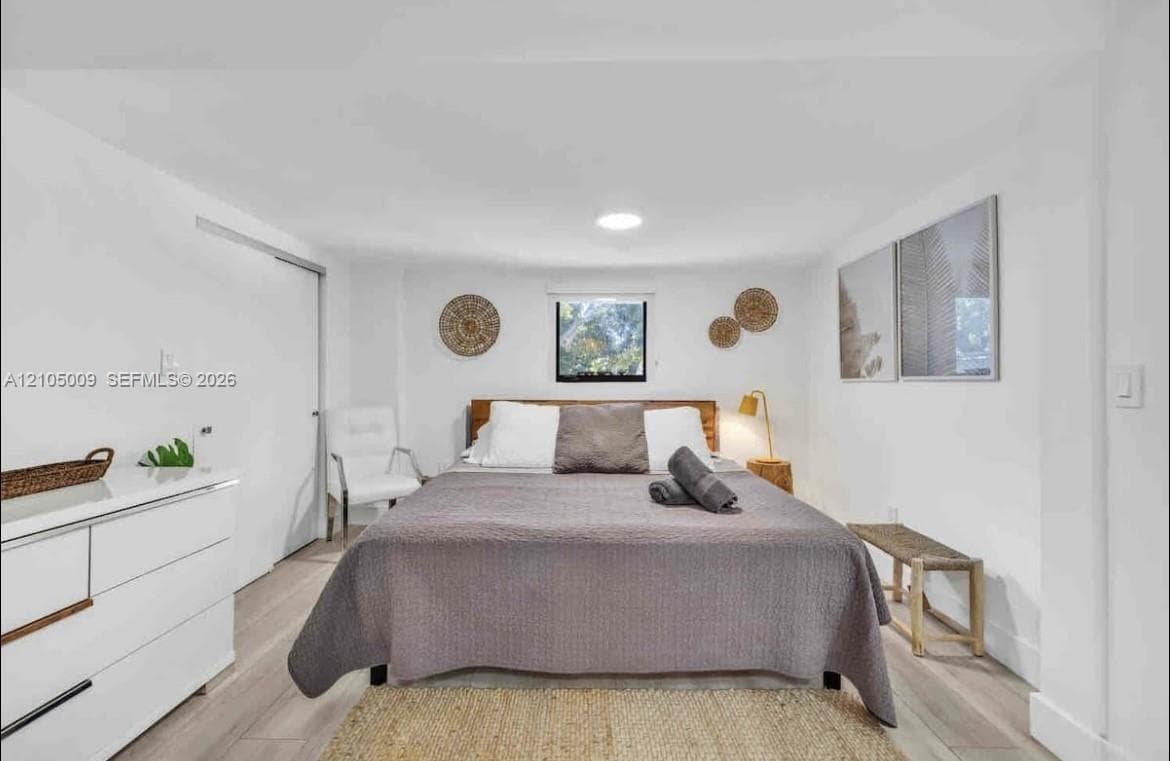 Light wood-finish flooring, white walls, and a recessed ceiling light