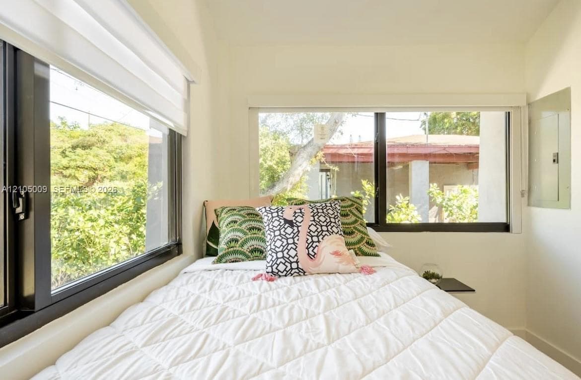 Dual windows with black frames and white window treatments