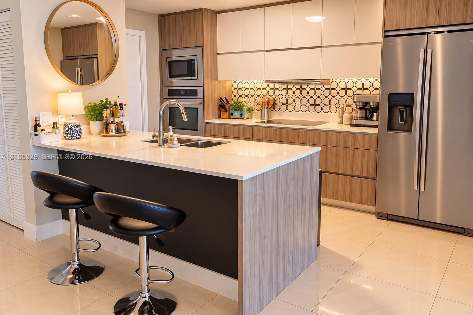 Kitchen featuring a wood-finish peninsula with a quartz countertop, flat-panel cabinetry, stainless steel appliances, and a geometric-patterned tile backsplash