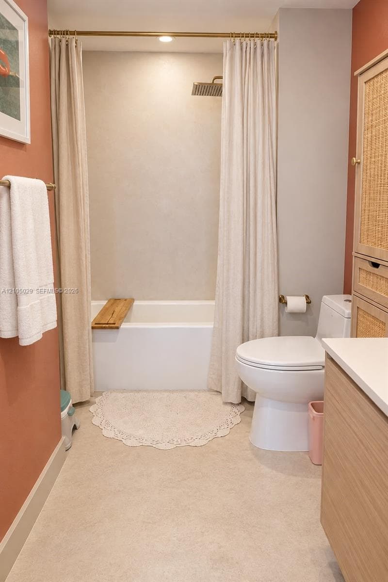 Bathroom featuring a soaking tub, wall-mounted rainfall showerhead, brass-finish fixtures, and a built-in wood-texture cabinet with woven door panels